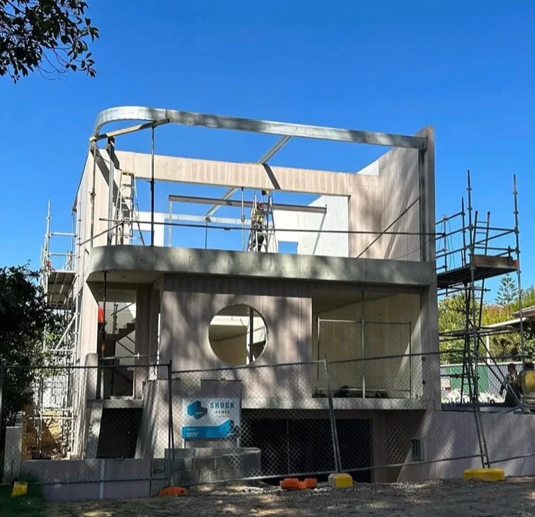 Swanbourne project under construction — concrete structure with circular window opening, scaffolding in place