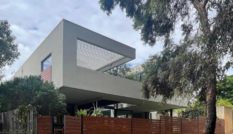 Street elevation — cantilevered upper level over the undercroft, timber-slat fencing, Wembley Downs